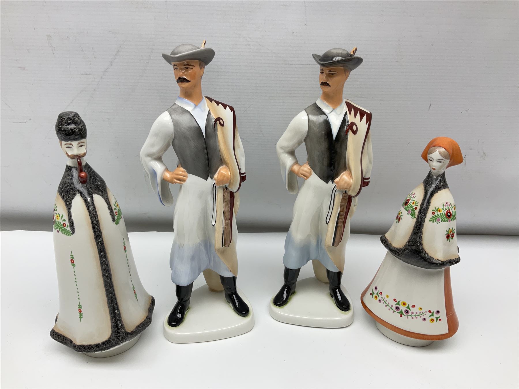 Group of eleven Aquincum of Budapest figures, comprising two of a man in a feather hat, seven dwarves, man and woman in traditional dress, all with printed marks beneath