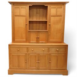 Yorkshire oak dresser, projecting top over open centre fitted with shelf, small double cupboard and flanking full height cupboards, the lower section fitted with three drawers and cupboards, enclosed by panelled doors, on plinth base