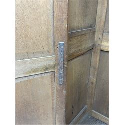 George III oak livery cupboard, projecting moulded cornice over two panelled doors, the upper panels within stepped ogee and arched moulded frame, the interior fitted with a single row of wooden hooks, two short and one long drawers, on bracket and return skirted base 