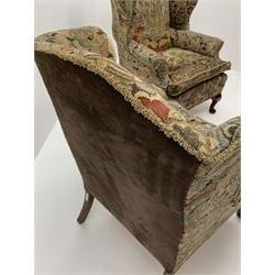 Matched pair early 20th century Queen Anne style wingback armchairs, walnut framed, sprung seats with seat cushions upholstered in needle work cover, shell carved cabriole front feet