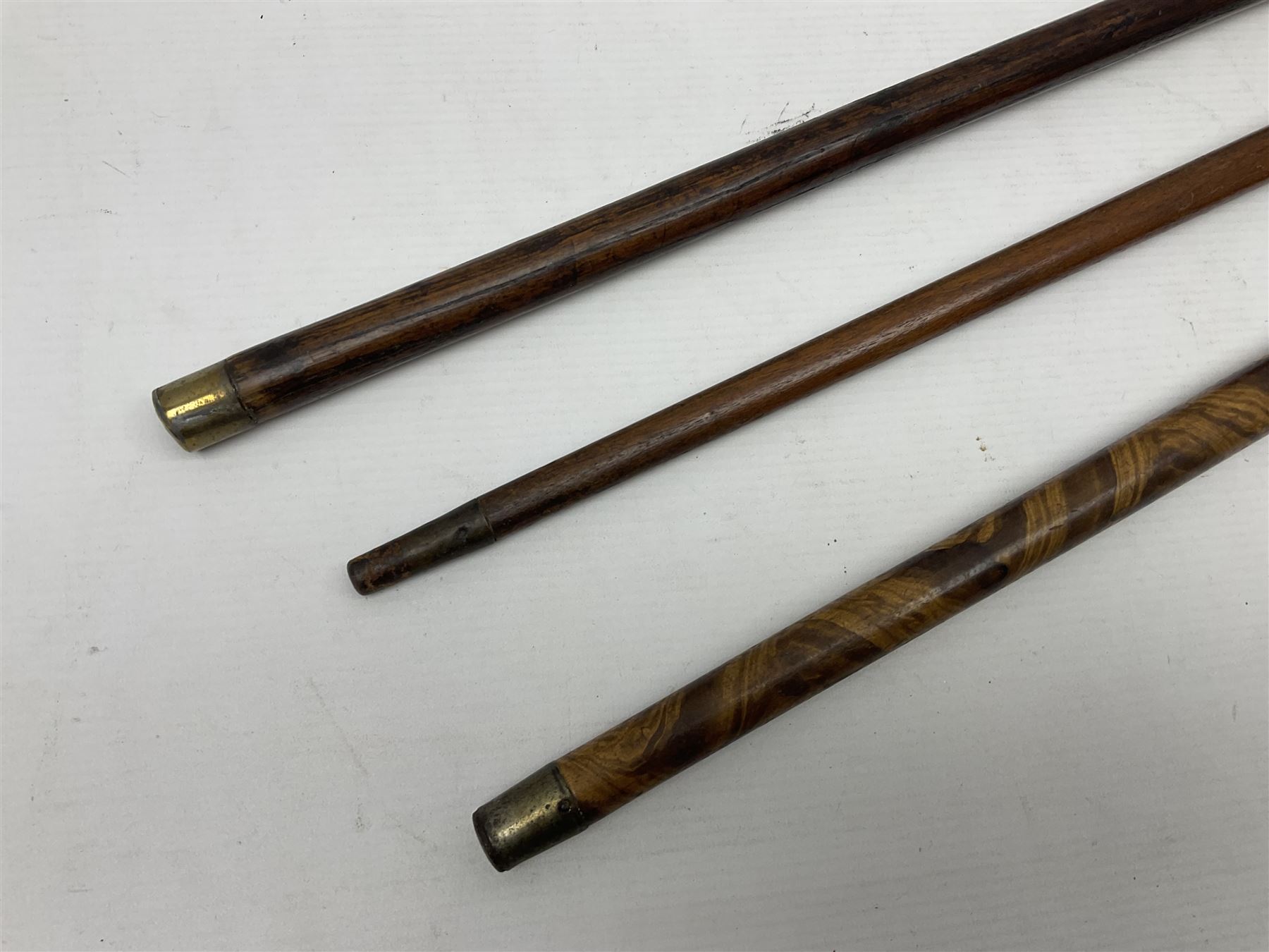 Three early 20th century walking sticks, to include a smoking pipe walking stick, the cane opening to reveal a concealed pipe, and a wooden walking cane, the metal cover with inscription 'bell metal and wood of York Minster, Burnt May 20 1840, and a turned wooden walking stick, with marquetry checkerboard pommel, tallest L90cm
