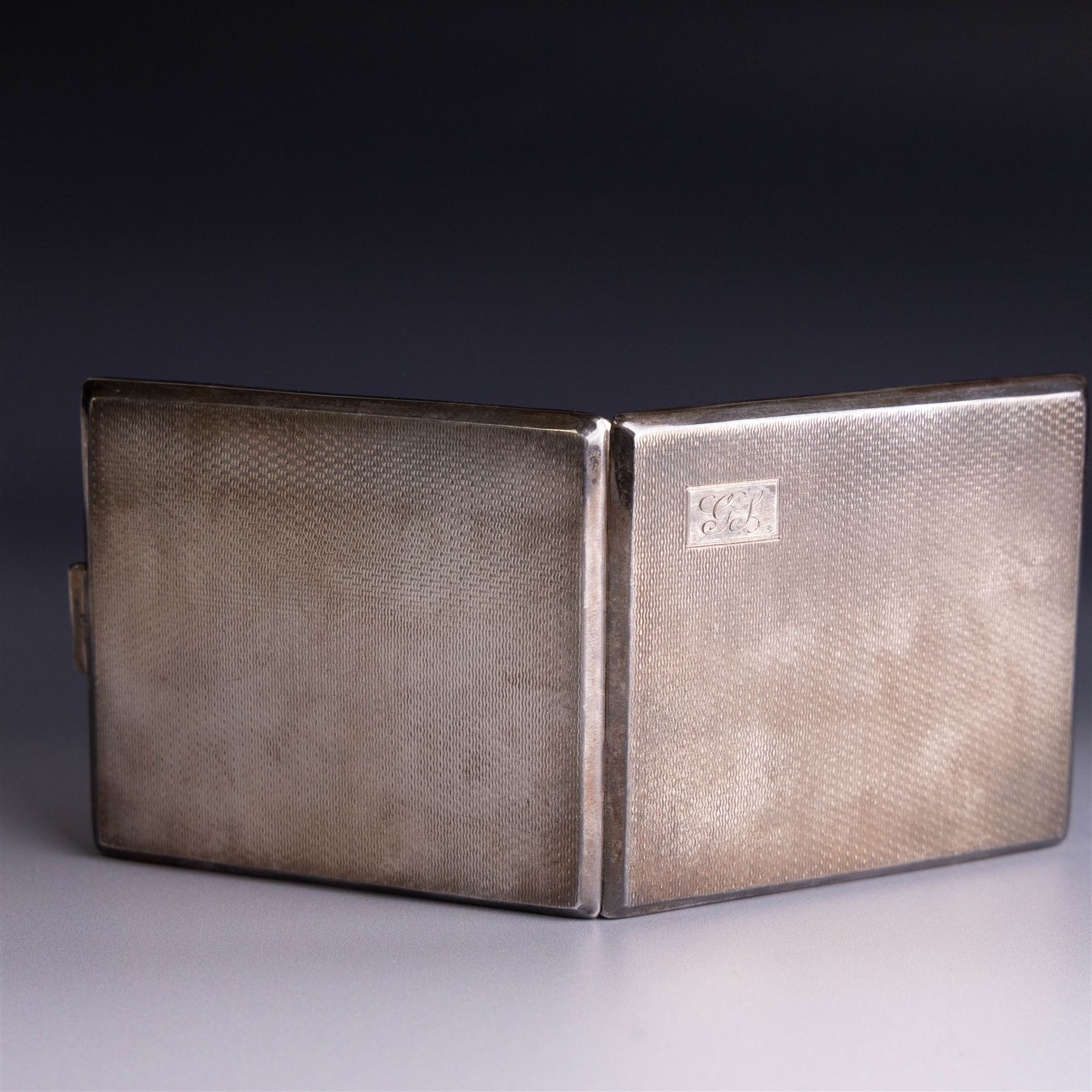 Mid 20th century silver cigarette case, with engine turned decoration and engraved initials to cover, with presentation engraving to the interior, hallmarked Harman Brothers, Birmingham 1947, H8.5cm, W9.5cm
