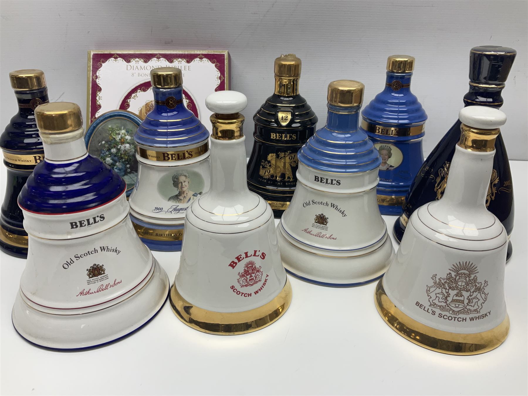 Bells, Scotch whisky, in seven Wade ceramic decanters, to include 50 year reign HM Queen Elizabeth II, Ninetieth Birthday of the Queen mother, 1991 year of the sheep, etc, together with two empty decanters and other items 