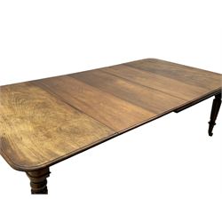 Early 19th century figured mahogany extending dining table, the rectangular top with moulded edge and rounded corners, pull-out action with three additional leaves, raised on turned and lobe carved supports with brass cup castors