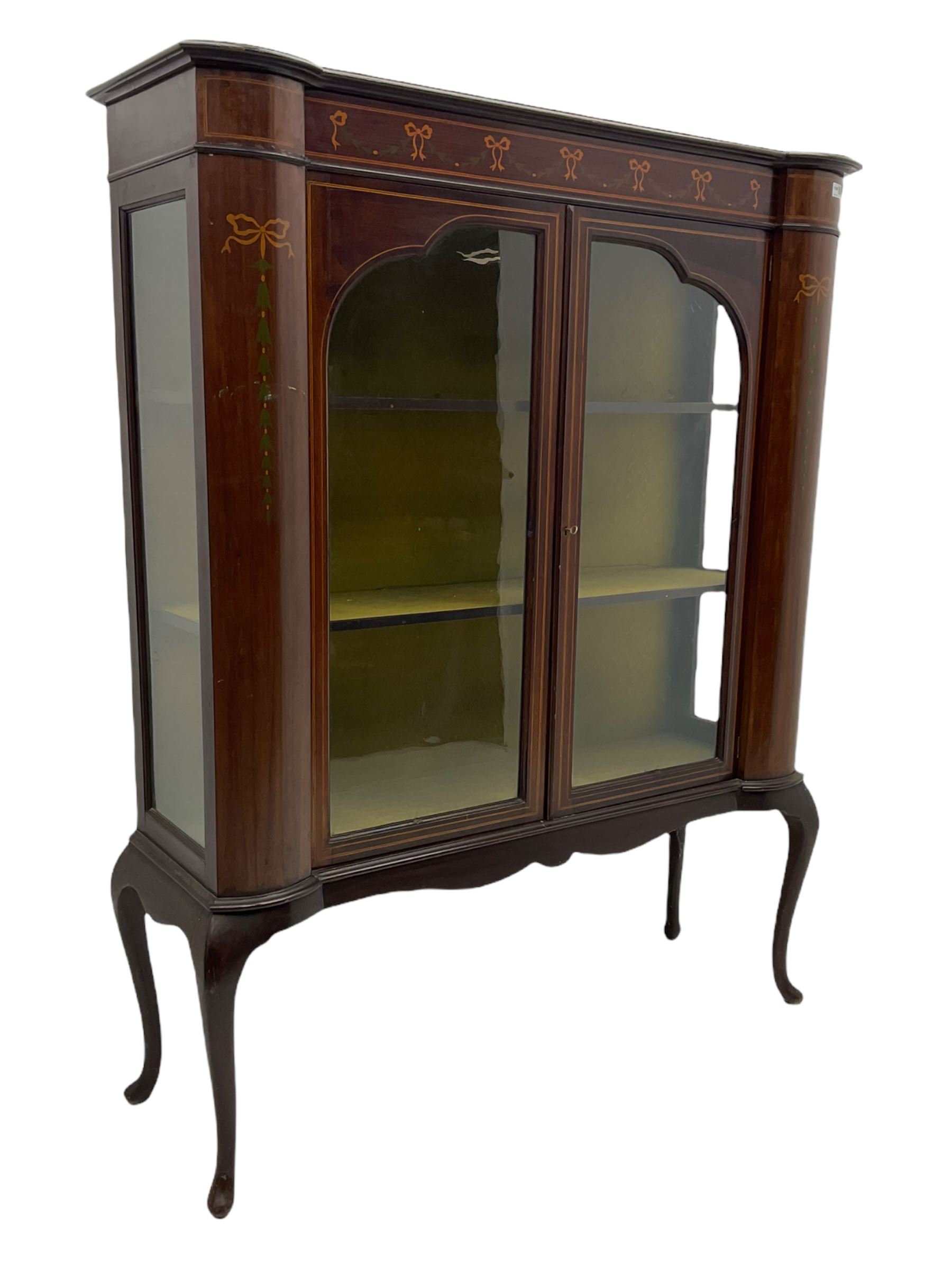 Edwardian mahogany display cabinet, shaped front with painted ribbon and bellflower garland decoration, enclosed by two glazed doors, cabriole supports