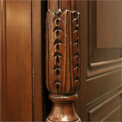 And So To Bed - French design ‘Eclectic’ double wardrobe in dark finish, arched moulded cornice with carved foliate band and turned finials, two mirrored doors enclosing a hanging rail, flanked by turned columns with foliate decoration, single fluted drawer below, on turned tapering feet