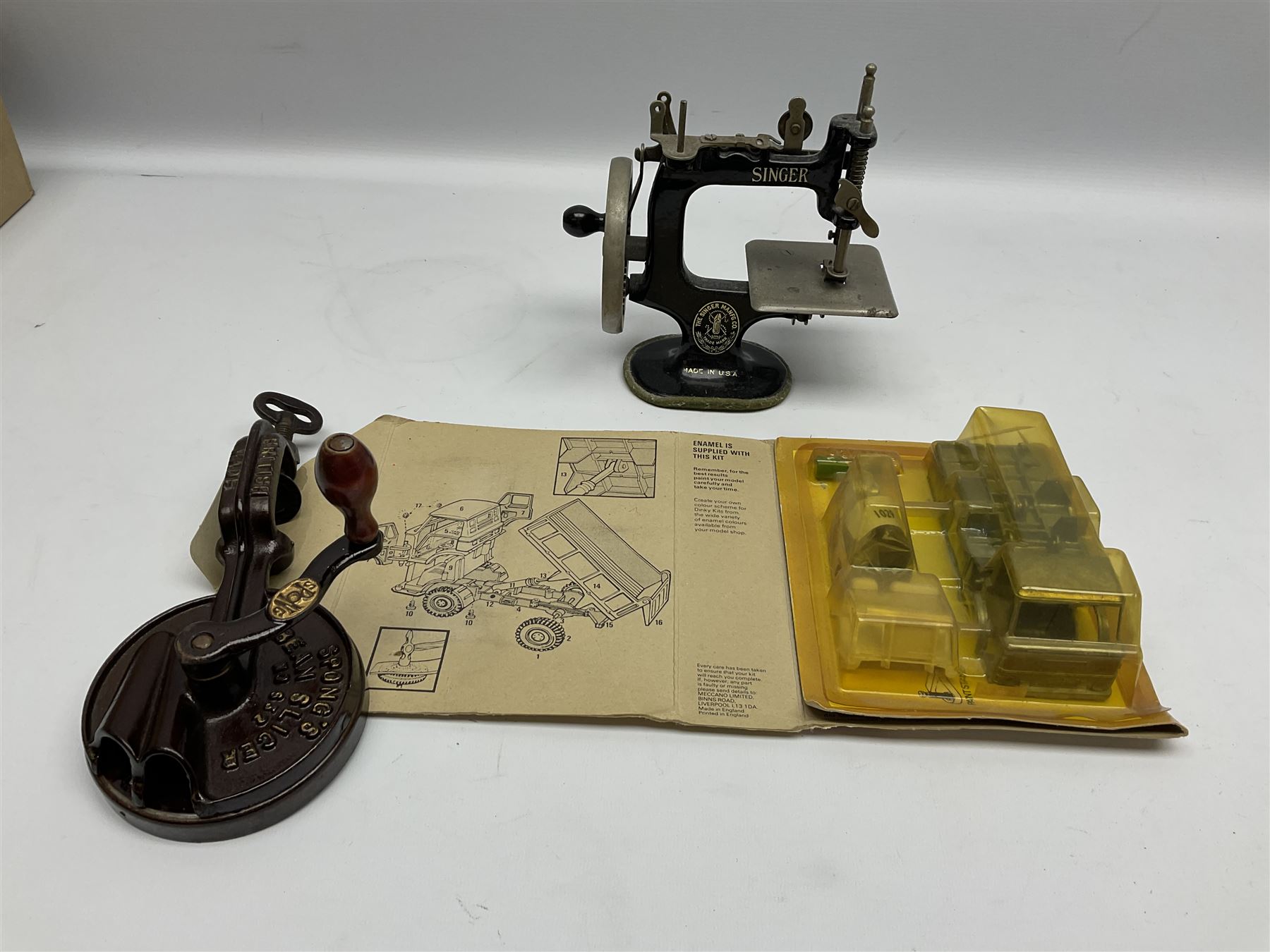 Dinky Kit No.1029 Ford D800 Tipper Truck in unopened original packaging; American Singer child's sewing machine; Spong's table mounting Bean Slicer No.632; and two wall mounting wooden die-cast model open display racks (5)