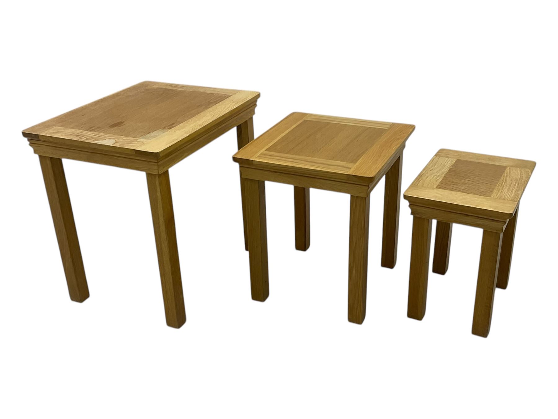 Contemporary light oak nest of three tables, each with rectangular top with moulded edge, raised on square supports