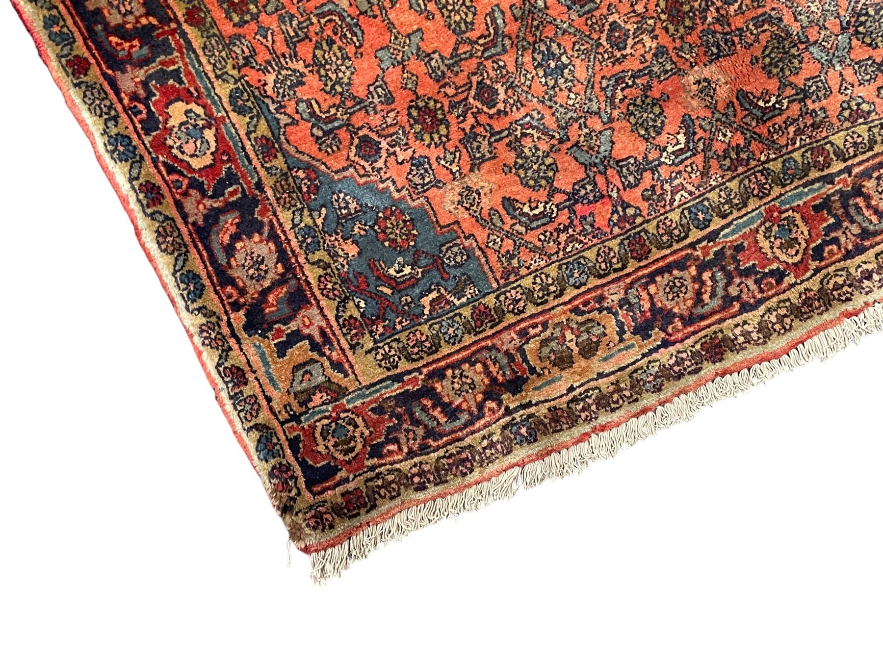 Persian Zanjan pale red ground rug, lozenge medallion and field decorated with floral Herati motifs, the border decorated with stylised plant motifs and trailing branches, floral pattern guard stripes