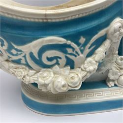Rare 19th century Minton turquoise glaze majolica 'The Reader' flower holder, after Albert Carrier-Belleuse, modeled as a maiden in classical drapery reading whilst leaning against the pillar back of the helmet shaped cistern detailed with a caryatid and floral swags, the whole upon an oval plinth with Greek key border, with impressed marks beneath, H44cm