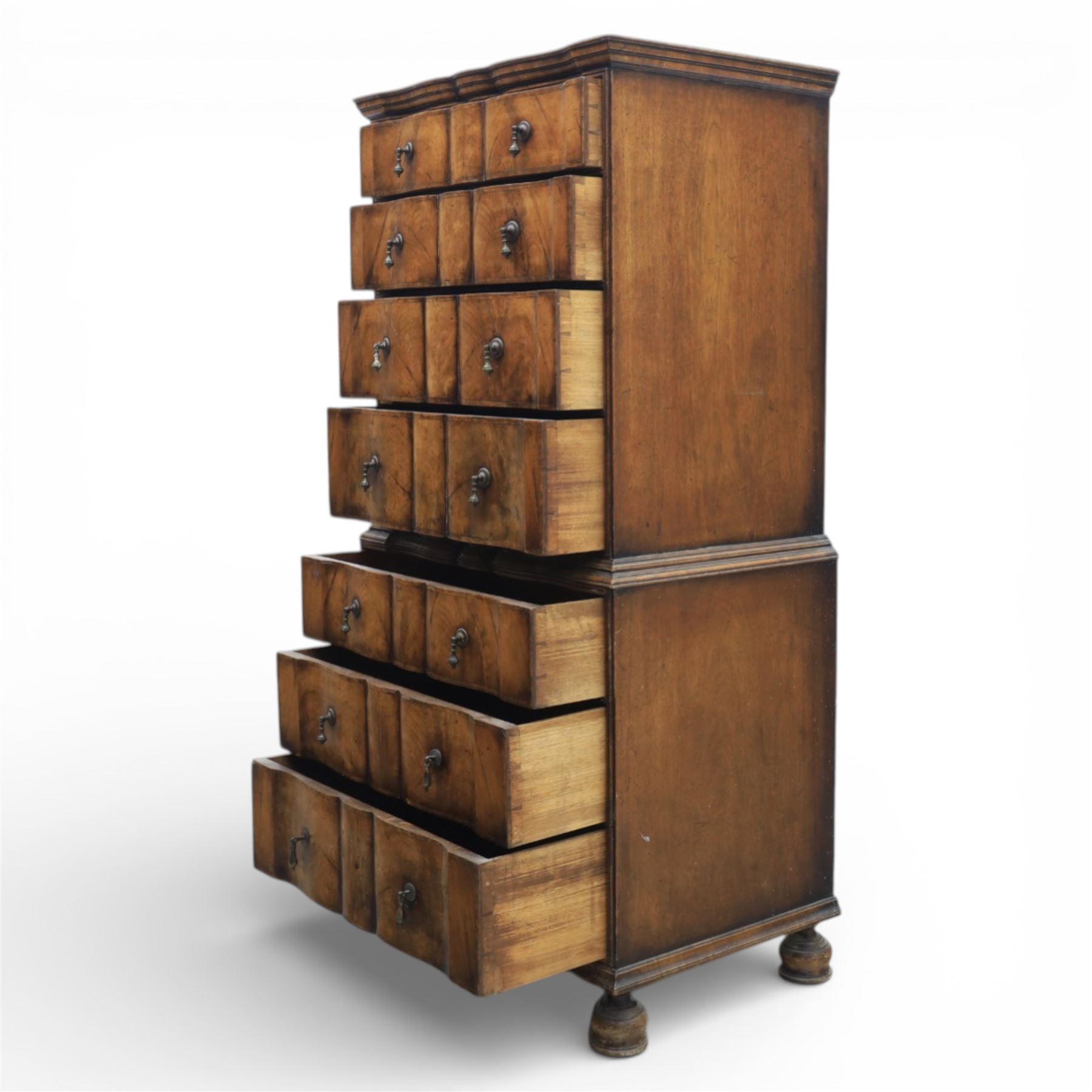 Early 20th century Queen Anne revival walnut chest on chest, the shaped cornice over an arrangement of four long drawers above three further long drawers, figured walnut veneers with feather banding and crossbanding, on turned bun supports