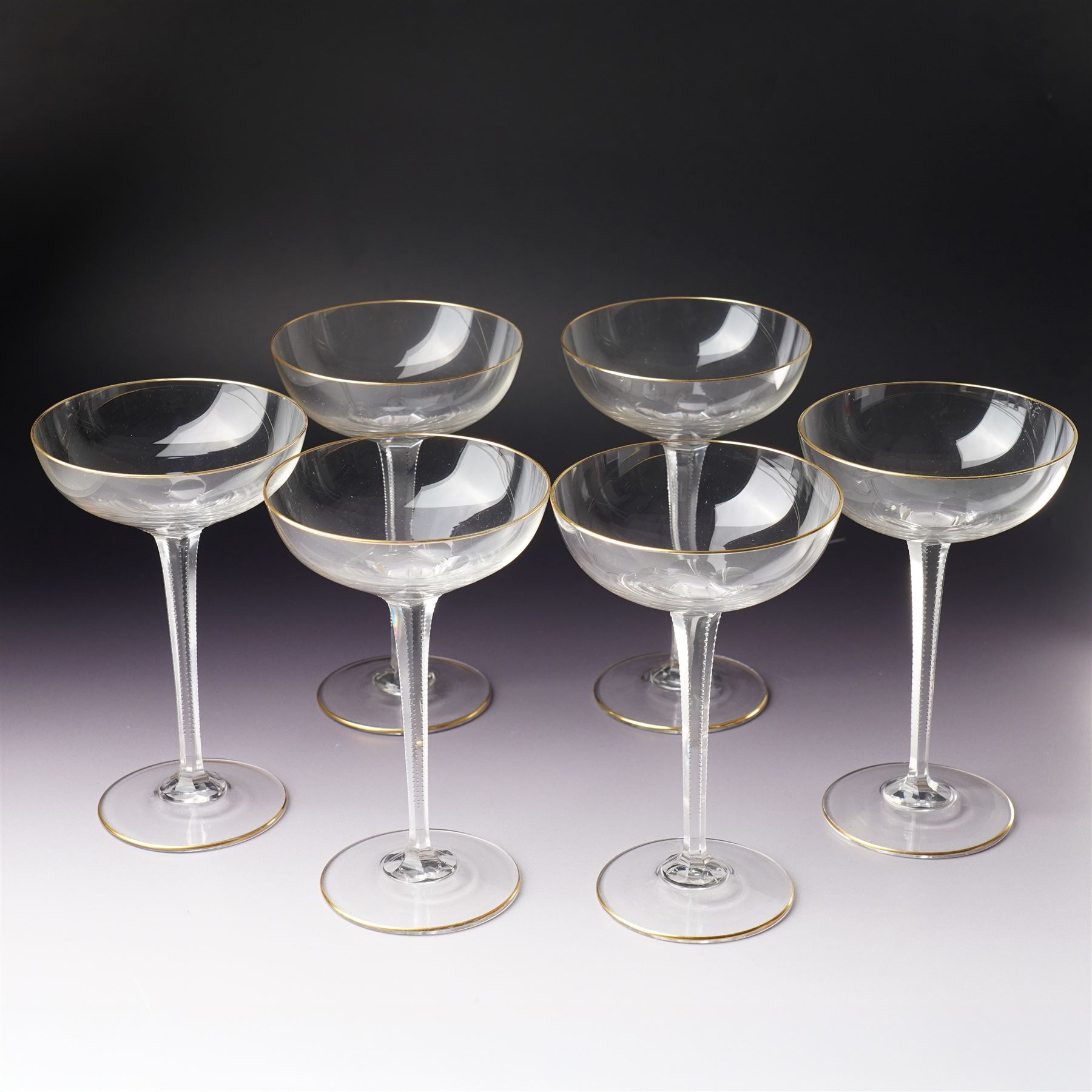 Set of six Wiener Werkstatte champagne coupe glasses, with gilt trimmed rim and foot, the faceted trumpet stem with toothed edges, H17cm 