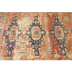 Antique Caucasian crimson ground carpet. the field decorated with three geometric indigo medallions with surrounding geometric motifs and guard lines