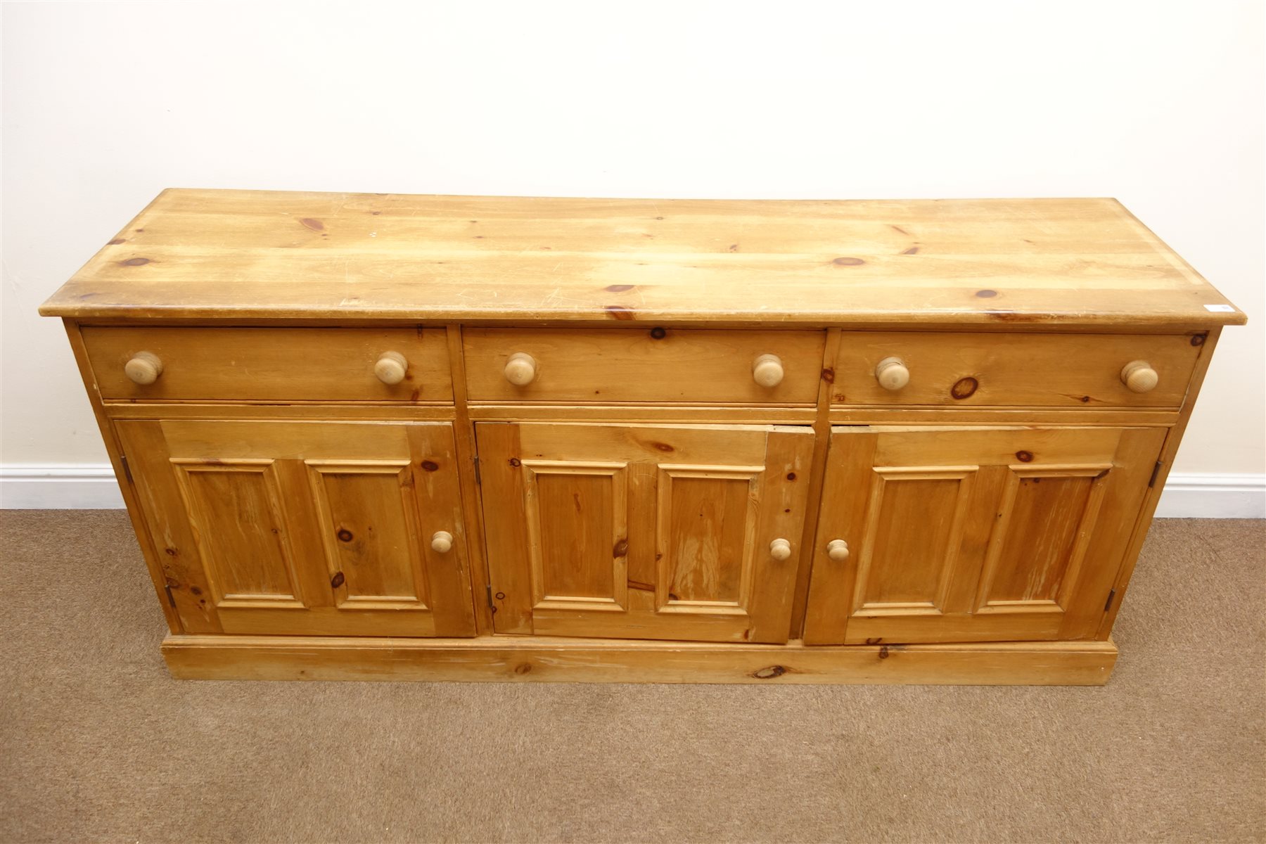 Solid pine dresser base, three drawers above three cupboards, plinth