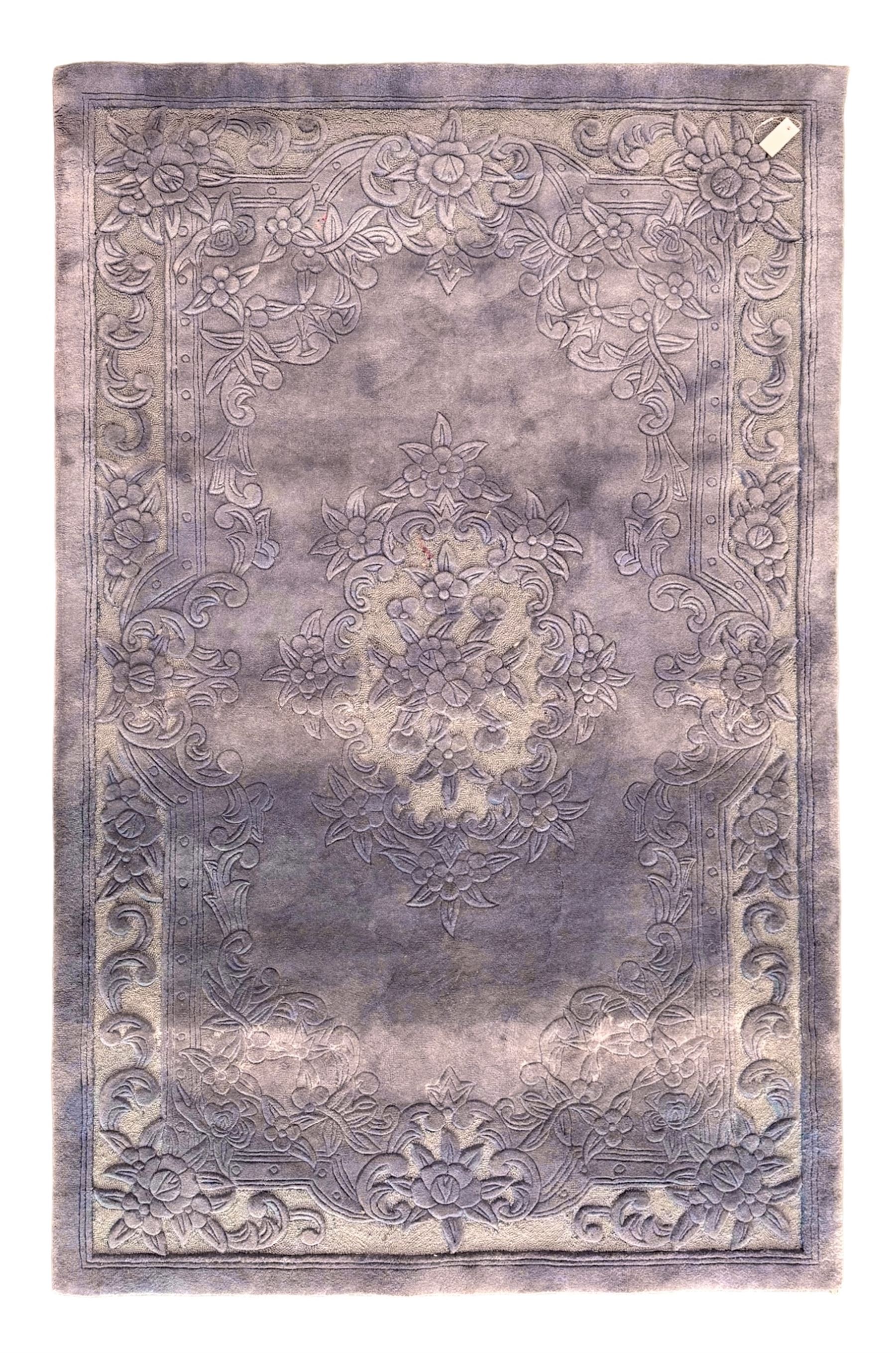Chinese wool rug, purple ground with tonal floral and foliate pattern, central medallion of stylised flowers, the corners with large rosettes, framed by broad border of scrolling floral and leafy motifs 