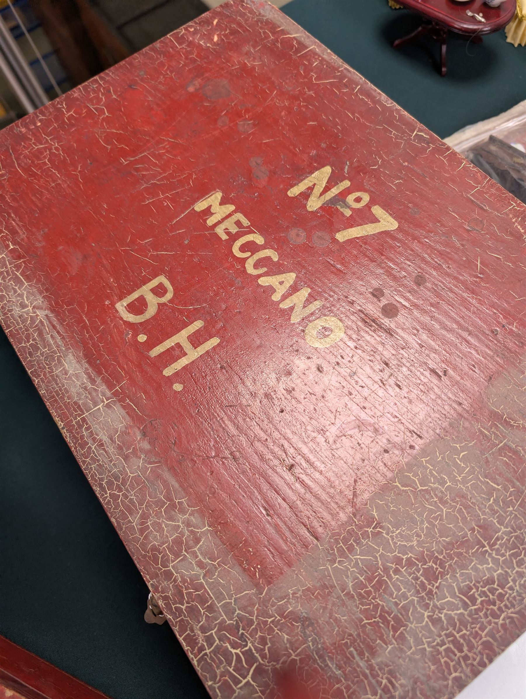 Mid 20th century Meccano outfit, including perforated strips, wheels, angled plate, boiler, flanged plates, no. 1 clockwork motor, etc, contained within red wooden box, with hand painted lettering to the cover reading 'No.7 Meccano B.H'