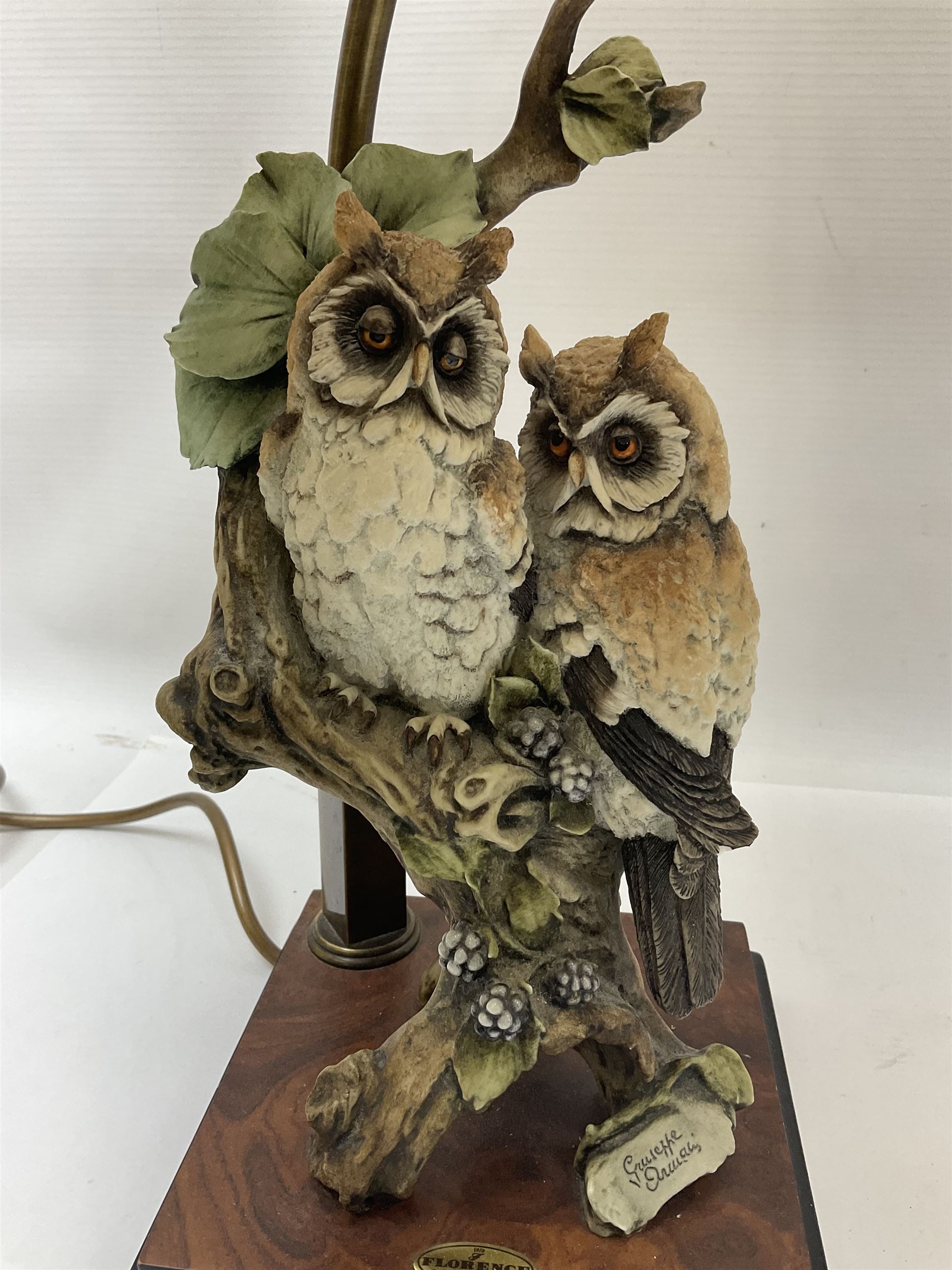 Two Giuseppe Armani figural lamps, the first modelled as an owl perched upon a book, the second modelled as a pair of owls perched upon blackberry branch, each with damask fabric tassel shades, tallest H76cm