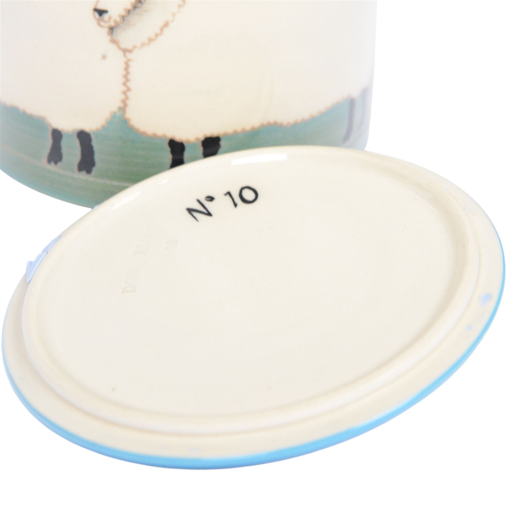 Dennis Chinaworks jar and cover, the body decorated with sheep, with a blue lid, impressed and painted marks beneath, H10cm