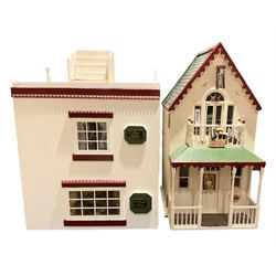 Seagull Pub - scratch-built wooden doll's house as a two-storey gable fronted public house painted in white green and maroon; the hinged front with ground floor veranda and window over opening to reveal two fully furnished rooms with dog-leg staircase and well stocked bar with bar-tender L31cm H62cm D37cm; together with Corner Shop and Dollies Pantry; a similarly painted scratch-built wooden two-storey flat-roofed doll's house as a well stocked ground floor grocery shop with stairs up to two further fully furnished rooms and more stairs giving access to a roof terrace L46cm H57cm D33cm (2)