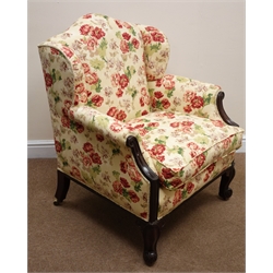  Early Victorian mahogany low upholstered armchair, arched wing back and loose seat cushion in vintage floral Sotherton fabric by Nouveau, cabriole legs with scroll feet and recessed brass castors,   