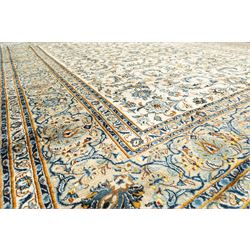 Central Persian Kashan hand-knotted carpet, ivory field profusely decorated with an all-over scrolling vine, palmette, and lotus design in shades of soft blue, pale gold, and green within floral borders