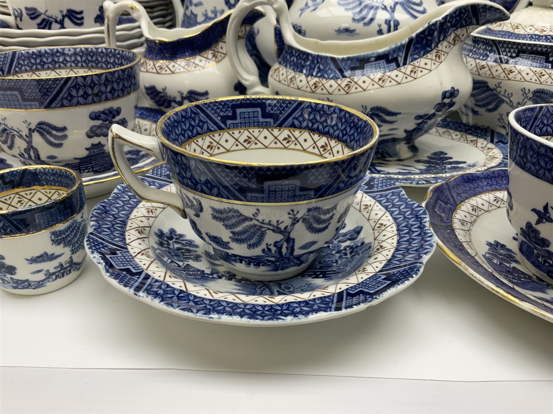 Booths Real Old Willow pattern part tea and dinner service, to include two meat platters, cake stand, teapot, two jugs, sugar bowl, sauce boat, teacups and saucers and a collection of plates and bowls
