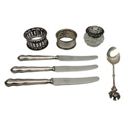 Two silver napkin rings, silver spoon with thistle top terminal, two silver handled butter knives, and small glass jar with silver cover, all hallmarked, approximate weighable silver 53.7 grams