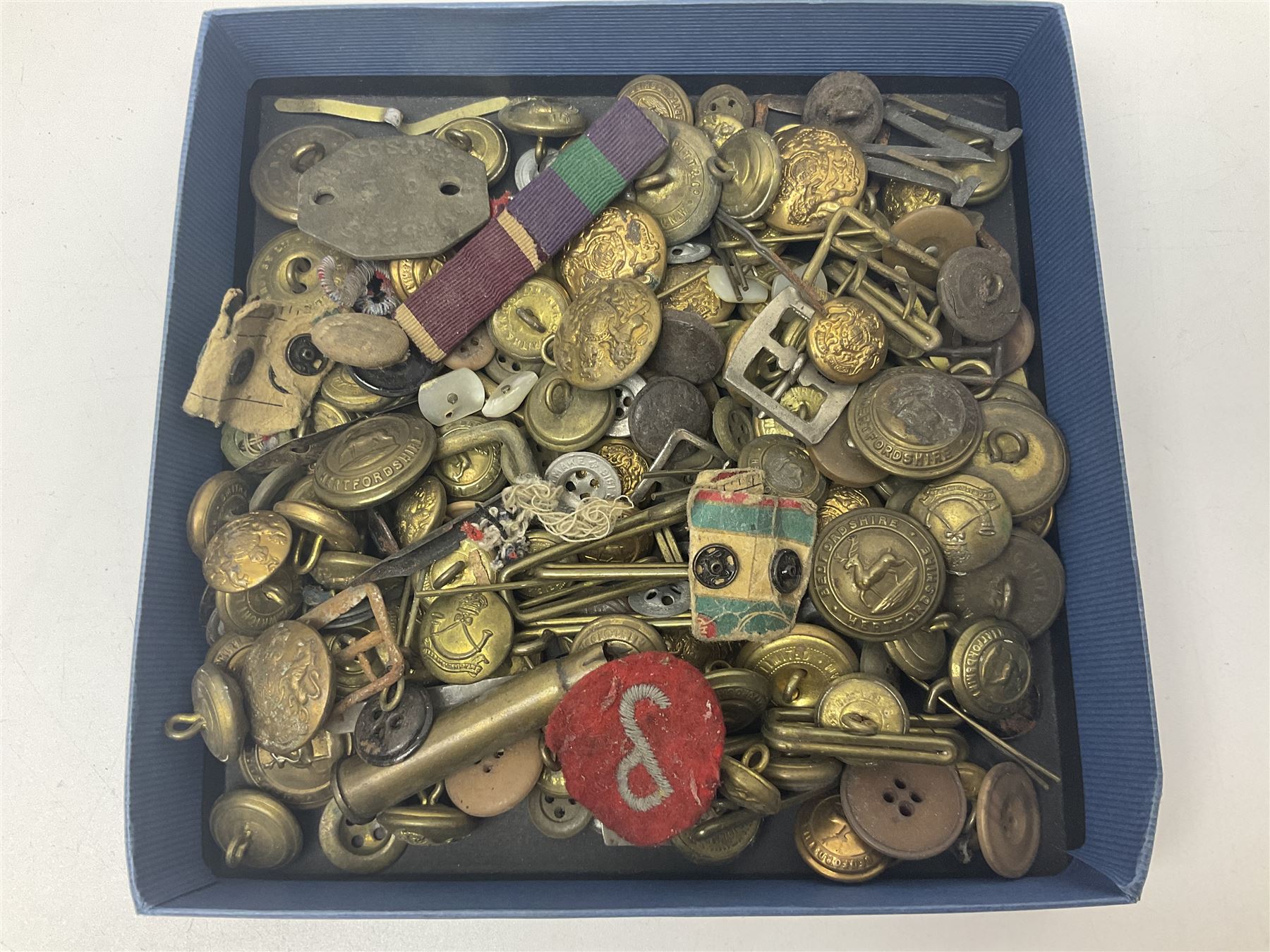 Over thirty British and Continental military metal badges; together with quantity of shoulder titles, collar dogs, rank pips, uniform buttons etc