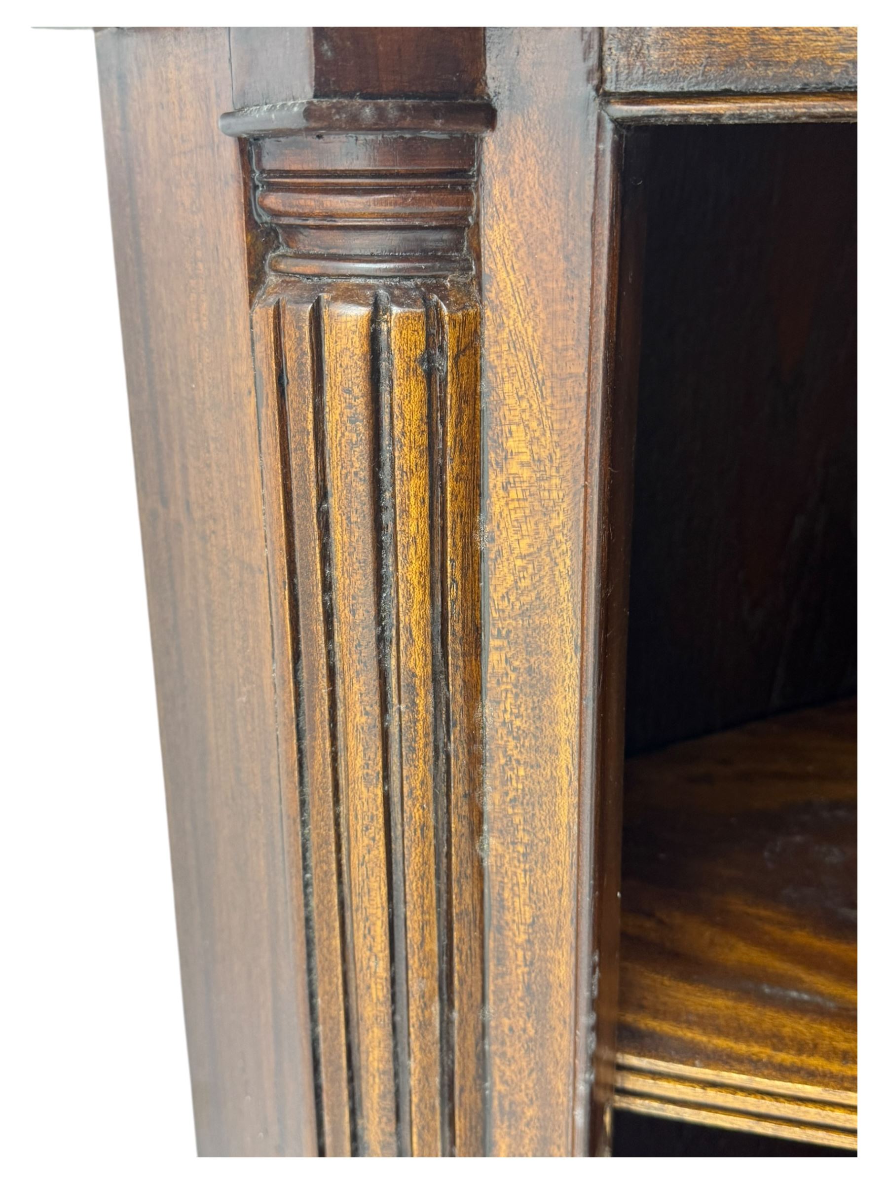 Late 20th century mahogany corner cabinet, dentil moulded cornice above a glazed door with astragal glazing enclosing two shelves, lower cupboard with fielded panel door and turned shell motif, on plinth base
