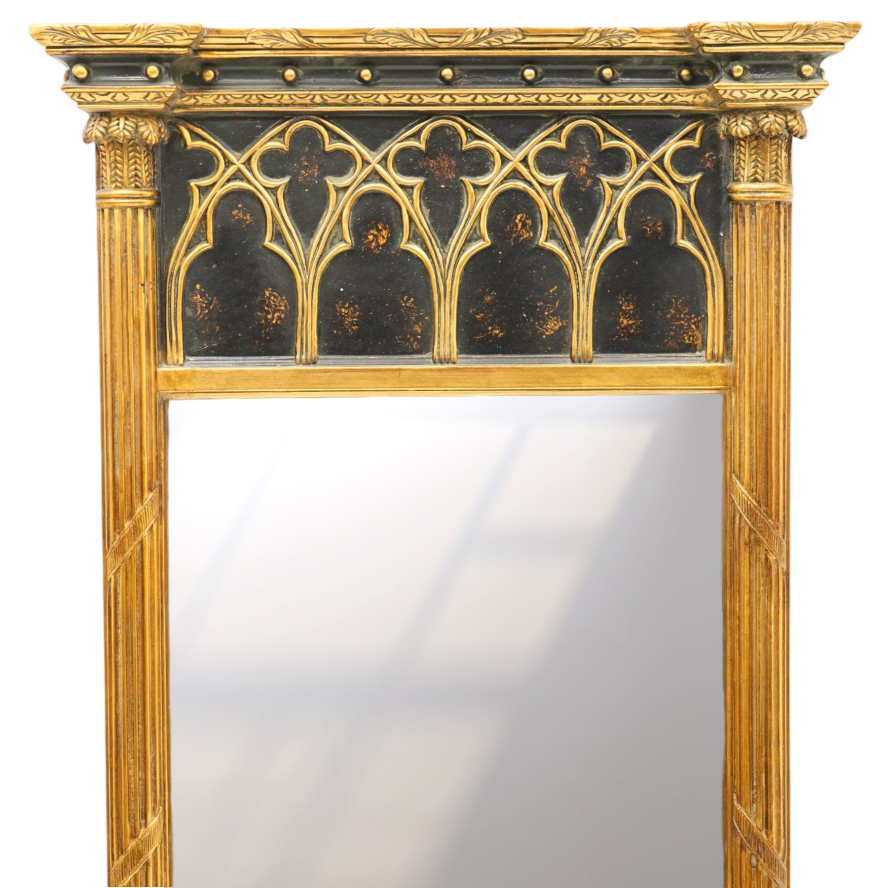 Tall Gothic Revival ebonised and gilt pier mirror, the projecting cornice with foliate ornament and applied spherical mounts, over a Gothic tracery frieze with trefoil motifs, the bevelled rectangular plate flanked by fluted Neoclassical columns with acanthus capitals, on a stepped ebonised and gilt plinth base with globular mounts