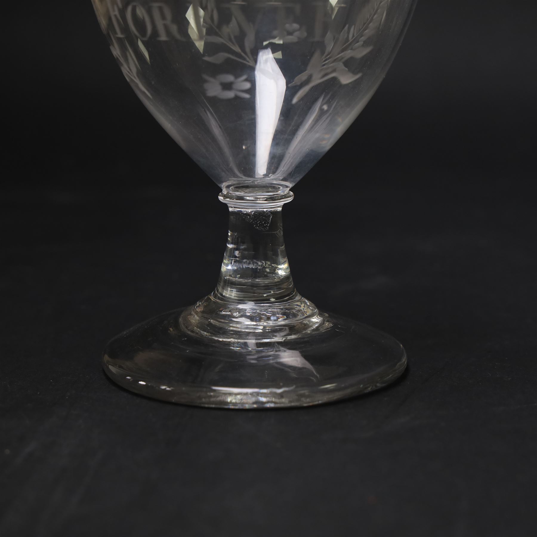 Early 19th century electioneering glass rummer, circa 1800-1830, the funnel bowl engraved with the inscription 'MORRITT FOREVER', and initials 'Y I M' verso, within leafy sprigs and beneath a husk band to rim, upon a plain short spreading stem, upon conical foot, H13.5cm

John Bacon Sawrey Morritt (circa 1772–1843) of Rokeby Park was a traveller, classical scholar, landowner, politician, and friend of Sir Walter Scott. He sat in Parliament for Beverley (1799–1802) and later for Northallerton (1814–1818), periods when fiercely contested elections often produced engraved drinking glasses as campaign propaganda, which were distributed in taverns and at election dinners. Examples connected to local candidates such as this are particularly scarce and survive as rare intersections of political history and material culture. 