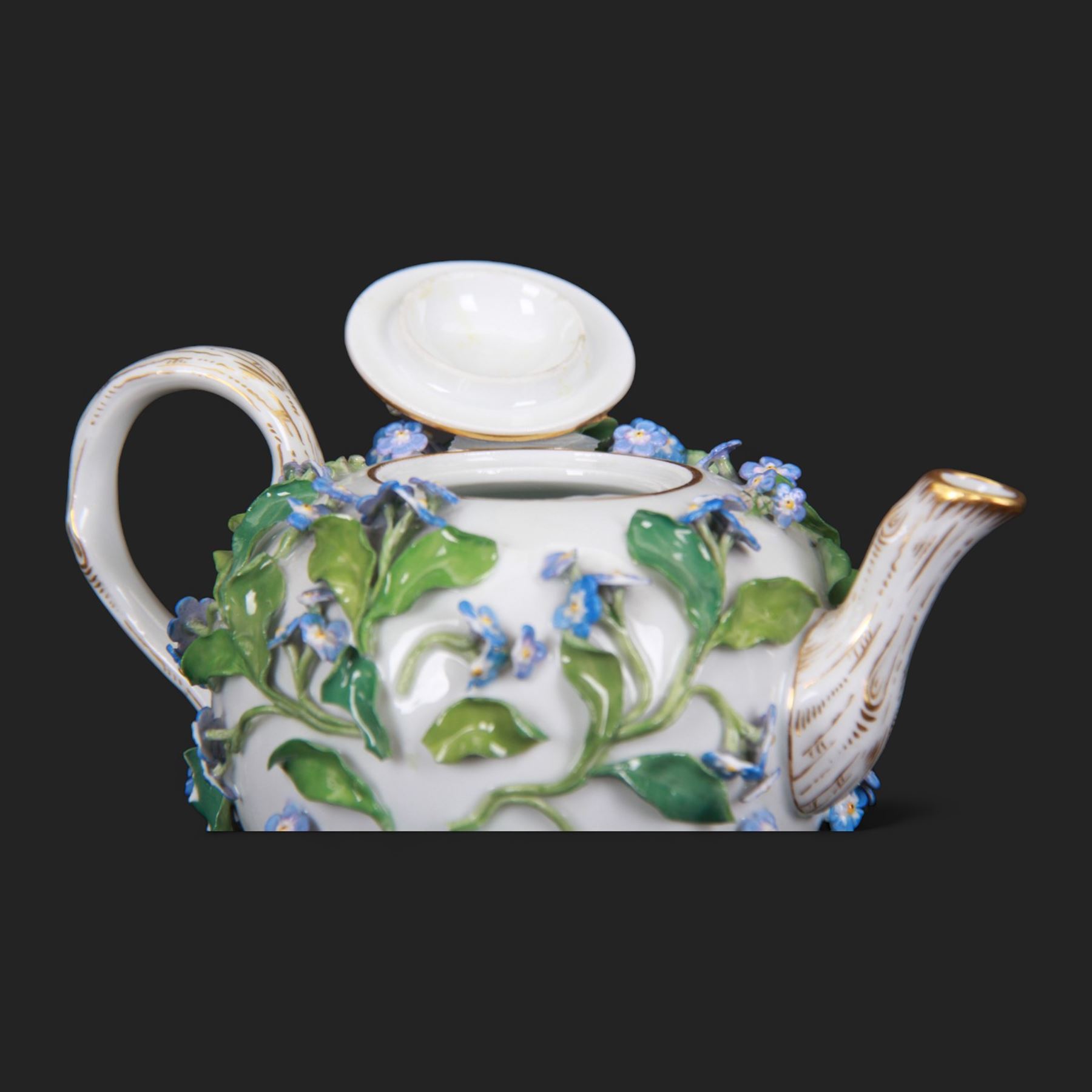 Late 19th century Meissen teapot, of ovoid form with gilt detailed 'crabstock' effect handle and spout, the body encrusted with forget-me-not flowers and leaves and painted with a single moth, with underglaze blue crossed swords mark beneath, H10cm