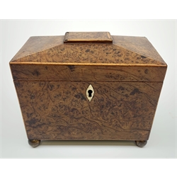 George III burr yew tea caddy, of sarcophagus form with lion mask ring handles and four brass ball feet, the hinged lid opening to reveal two compartments with cross-banded lids and traces of metallic paper lining, L19cm
