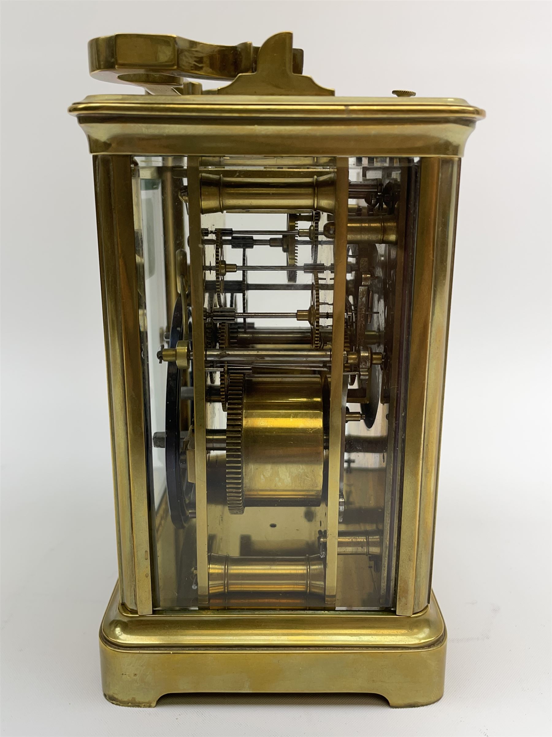 Early to mid 20th century French brass and bevelled glass cased carriage clock, the shaped loop handle over oval glass panel, white enamel Roman dial, twin train driven eight day movement striking on coil, with button push repeater, the movement back plate stamped for 'R & Co.'