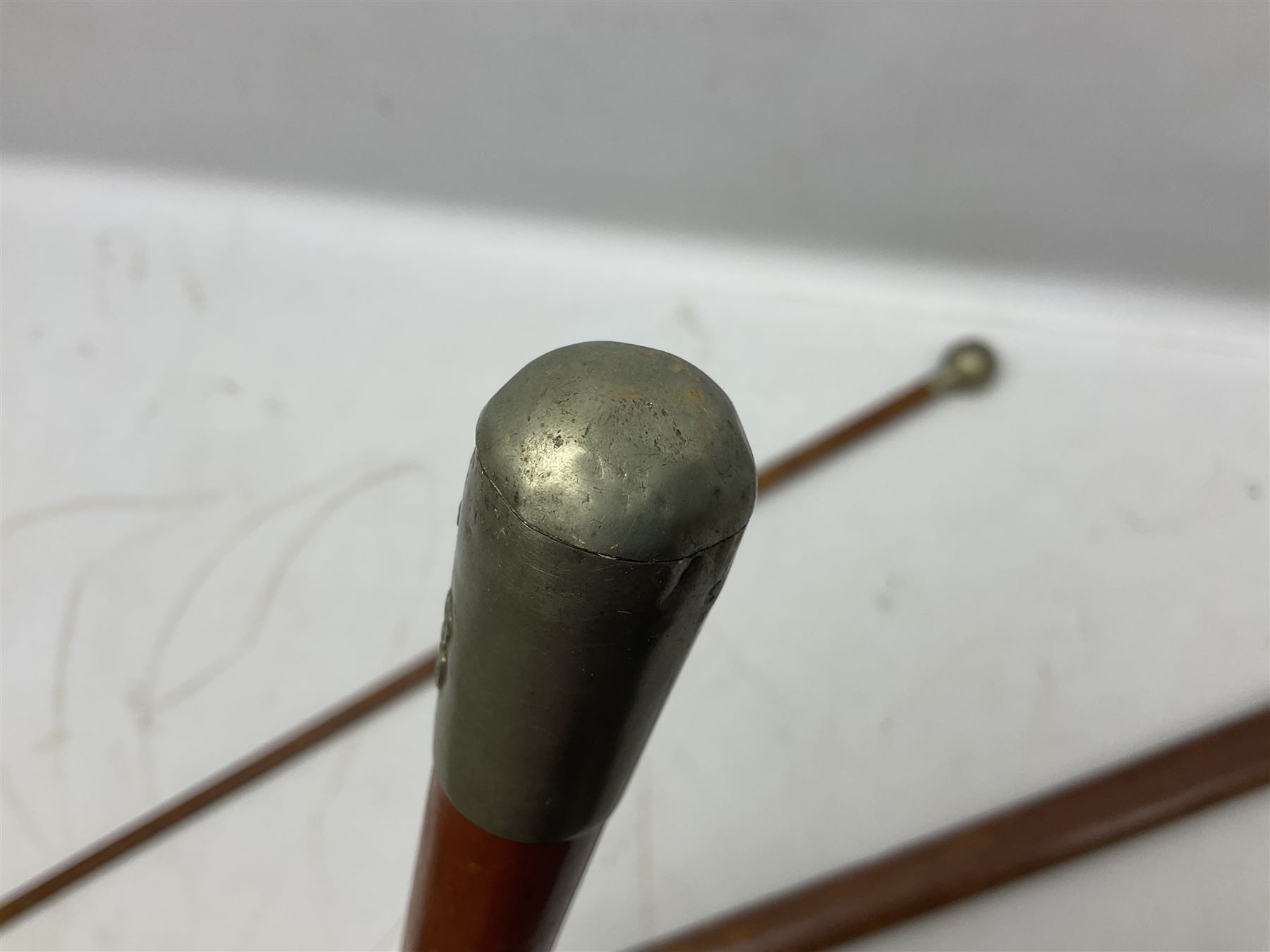 George V 1897 pattern Army Officer's sword by Henry Wilkinson Pall Mall London, the 82.5cm 'London Made' blade etched to both sides with Royal Crests and cyphers etc, pierced half-basket hilt with wire-bound fish skin grip and remains of leather knot strap; in leather covered field service scabbard L101cm overall; and two 14th Prince of Wales Own swagger sticks (3)