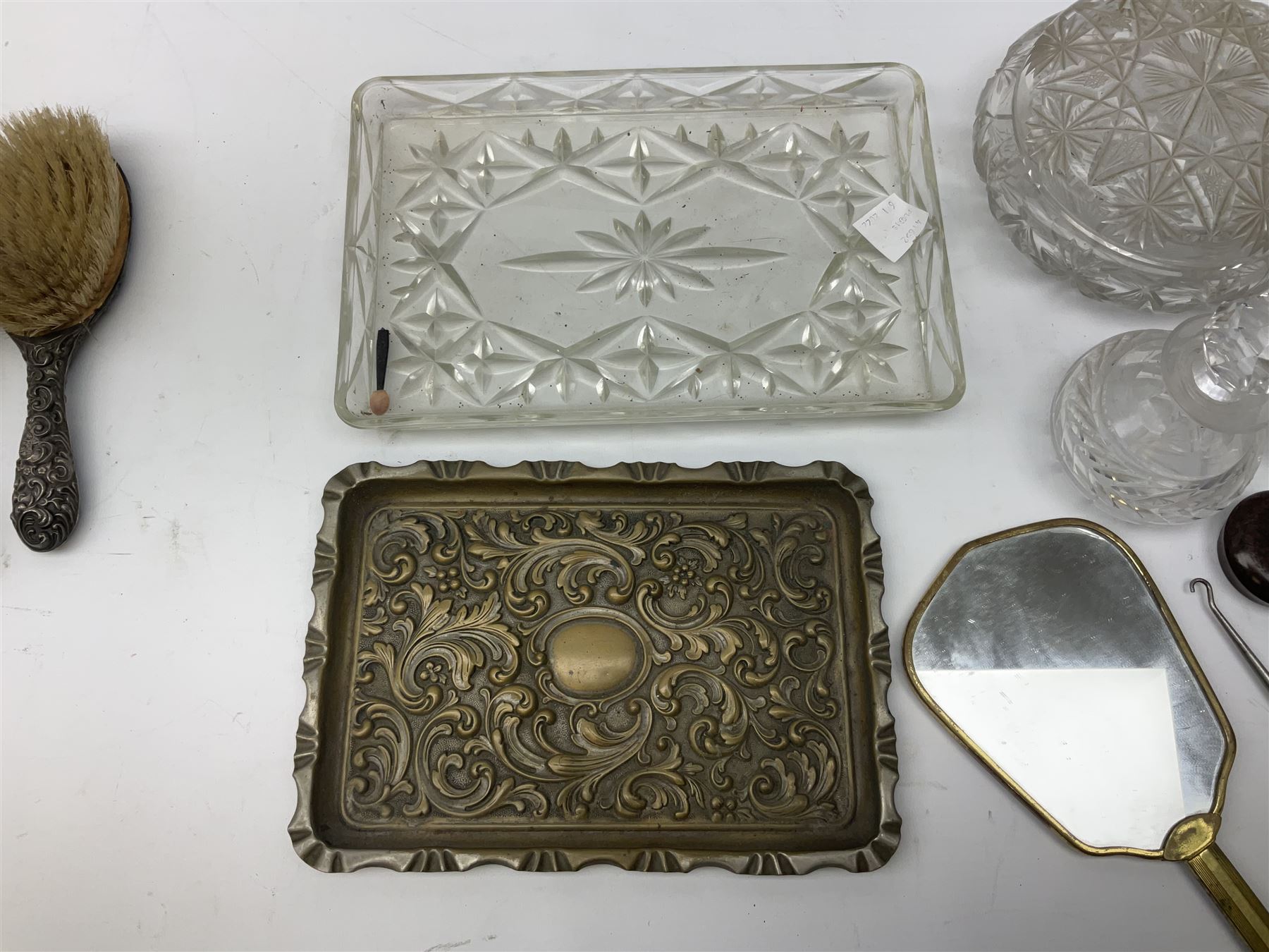 Glass dressing table tray, scent bottles and lidded bowl, metal mounted foliate design hair brushes and handheld mirrors etc