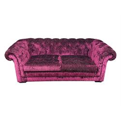 Contemporary Chesterfield design two-seat sofa, upholstered in fuchsia crushed velvet with a ribbed and tufted design, the rolled arms and deep-buttoned backrest raised on square block supports
