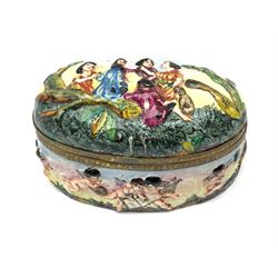 A large Capodimonte style trinket box, the hinged cover decorated in low relief with a figural scene, the base with cherubs, opening to reveal painted floral sprays to the interior, H9cm L16.5cm. 