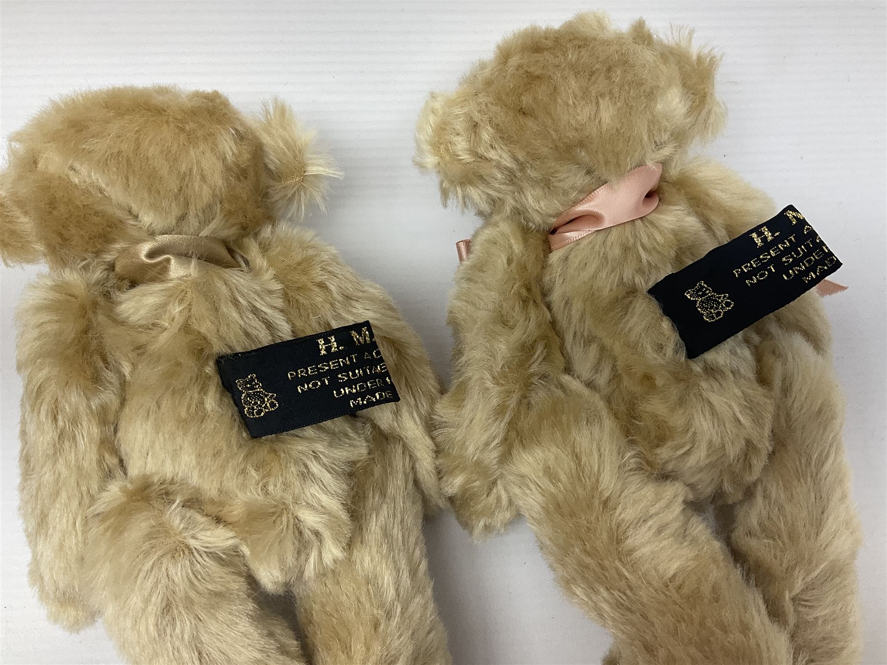 Group of five teddy bears comprising ‘George’ a unique pellet filled bear with glass eyes and velvet paws H38cm, and ‘Abbey’ a luxury German plush with wobble head and glass eyes no.5/10 H24cm, both with Teddies from Bearyland labels; along with two light blonde mohair H. M. Bears and Boyds Bears ‘T. F. Wuzzies’ no. 595140 (5)