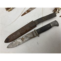 Indian kukri with 29cm curving steel blade and nickel mounted horn grip; in leather covered scabbard with one skinning knife L42cm overall; Hitler Youth knife with scabbard in relic condition; and three African graduated knives each with crudely carved wooden grips and painted leather covered scabbards (5)