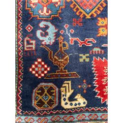 Persian Ardabil indigo ground rug, four interconnected lozenge medallions surrounded by ewer, bird, dragon, camel and geometric motifs, hooked border within guard stripes 
