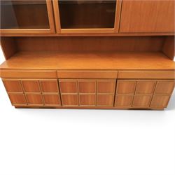 Mid-20th century teak wall display unit, featuring two glazed cupboards and fall front compartment with open shelves, above three drawers and cupboards to the base