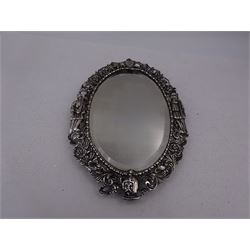 Continental silver miniature dressing table/wall mirror, of oval form with bevelled mirror plate, surrounded by a bead and dart rim, with pierced scrolling floral border with a standing cavalier to either side and the bust of a cavalier to the base, H17.7cm