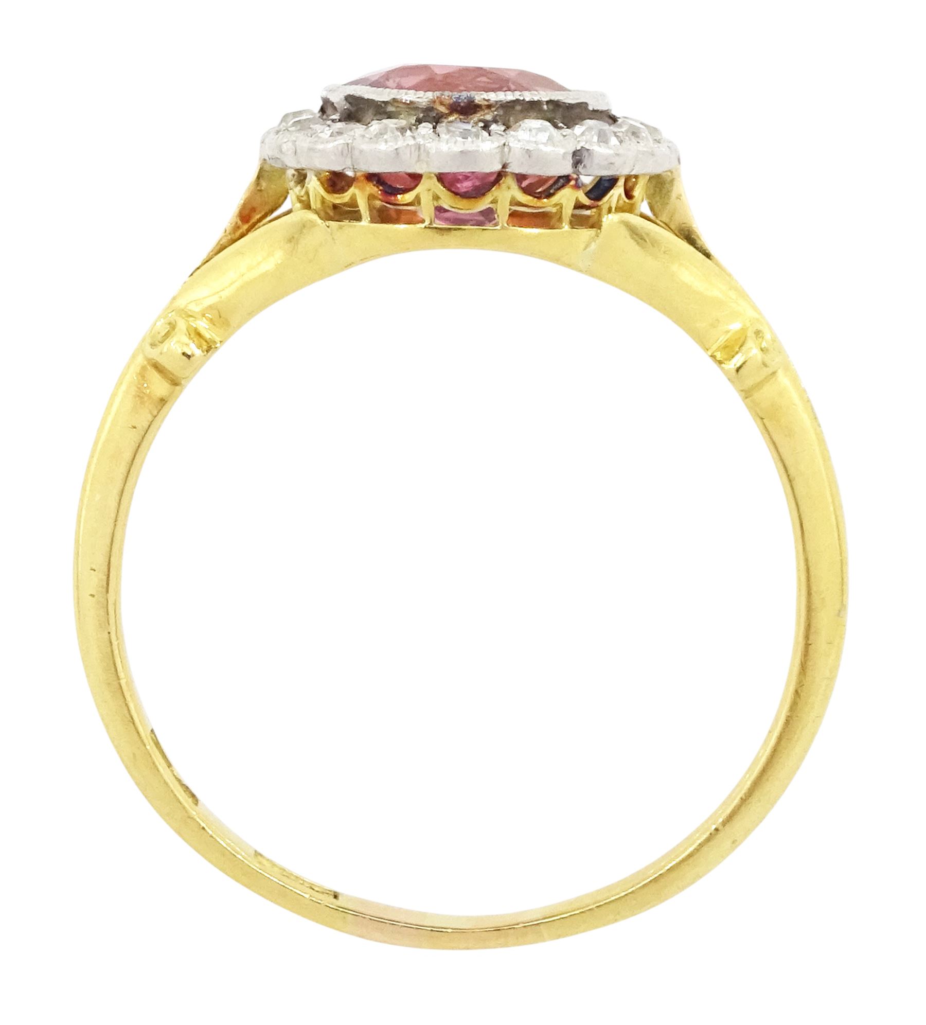 Early 20th century gold tourmaline and diamond cluster ring, milgrain set single stone pink tourmaline of approx 1.35 carat, surrounded by sixteen old cut diamonds, to a split design scroll shank, stamped 18ct, total diamond weight approx 0.30 carat