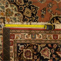 Persian Kashan style rug, salmon pink ground, central conforming lobed medallion in ivory and indigo, with palmette pendants, framed scrolling arabesques of lotus blossoms and palmettes, within navy border of meandering vines and flowerheads between ivory guard stripes 