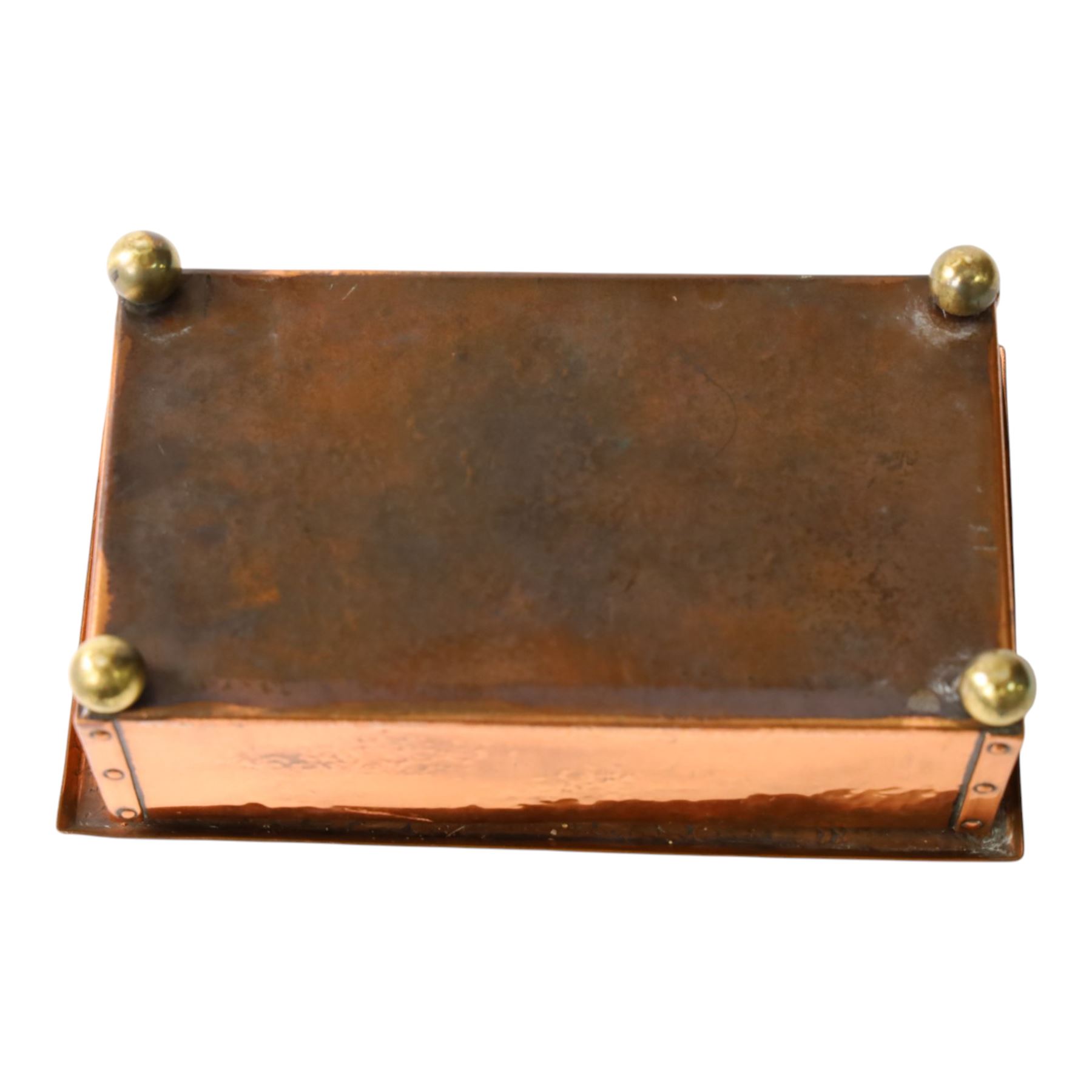  Arts & Crafts copper and enamel box, of rectangular form, the hinged lid with central enamel cabochon overlaid with pierced copper butterfly motif, raised on brass bun feet, H7cm, L17cm