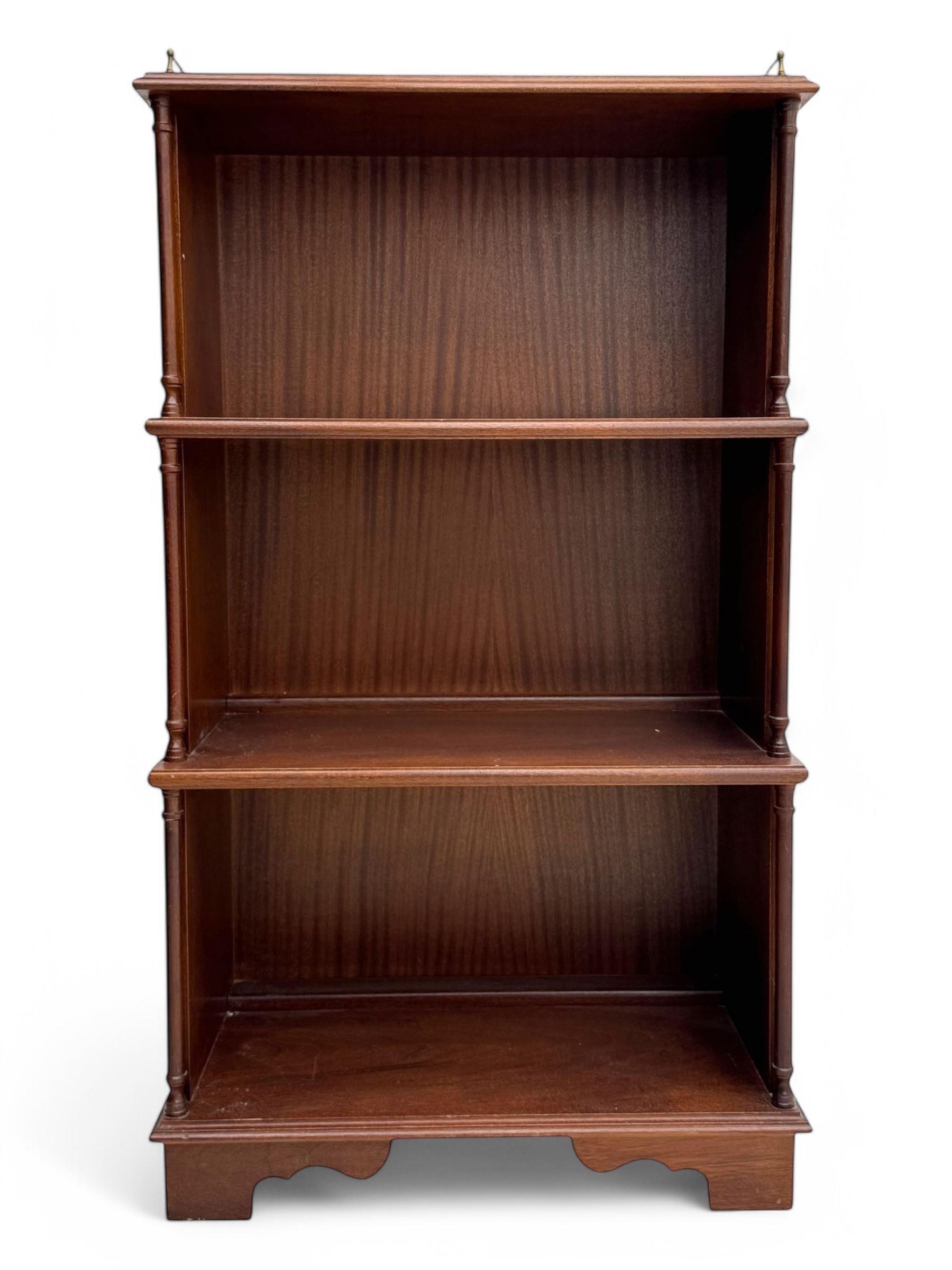 Mid-20th century mahogany open bookshelf, the rectangular top with a brass balustrade gallery, over three shelves each supported by turned column uprights, on shaped apron base