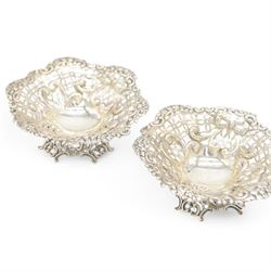Pair of late Victorian silver bon bon dishes, of hexagonal form with embossed and pierced scrolling decoration, upon a circular pierced base, hallmarked Goldsmiths & Silversmiths Co, Birmingham 1893, W11cm, H4cm