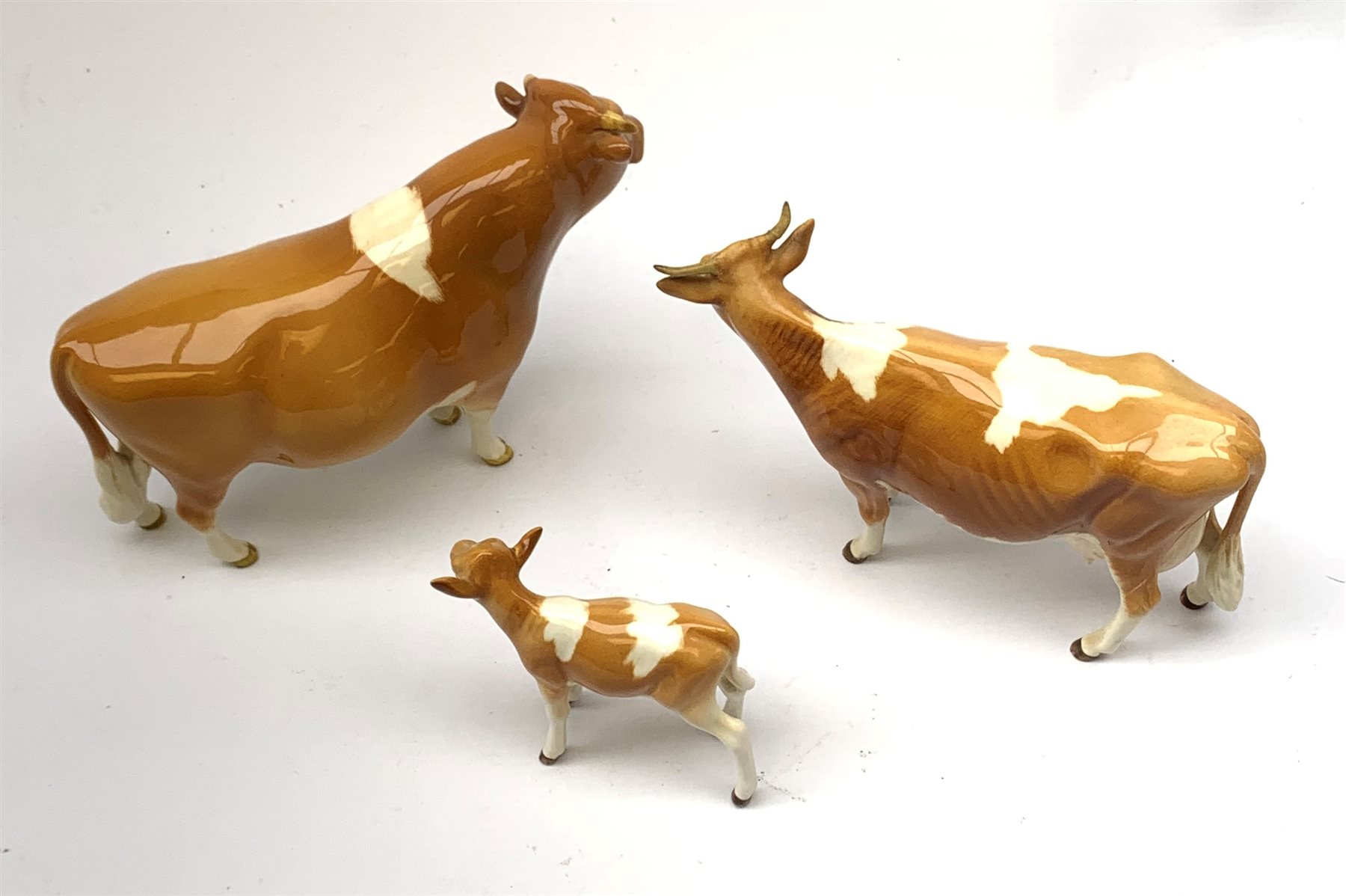 A Beswick Guernsey Bull 1451, marked Ch Sabrina's Sir Richmond 14th, Guernsey Cow, and Guernsey Calf, each with printed mark beneath. 