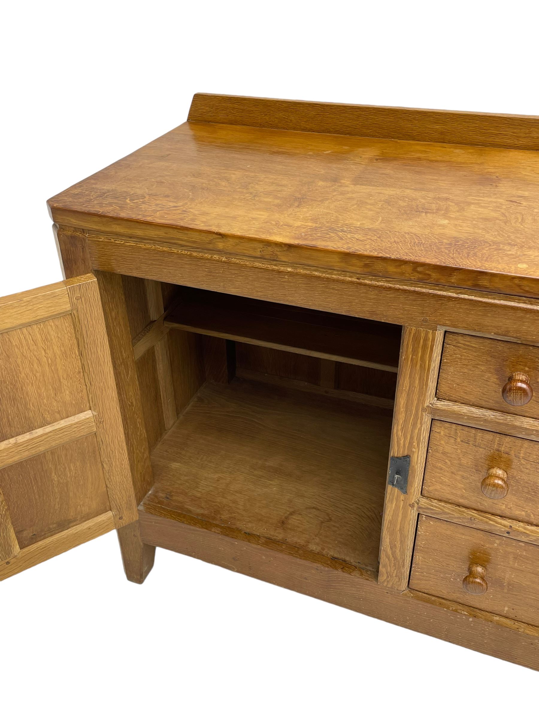 Rabbitman - adzed oak sideboard, fitted with three central drawer and two flanking cupboards, panelled doors with iron latches and hinges, carved with rabbit signature, by Peter Heap, Wetwang